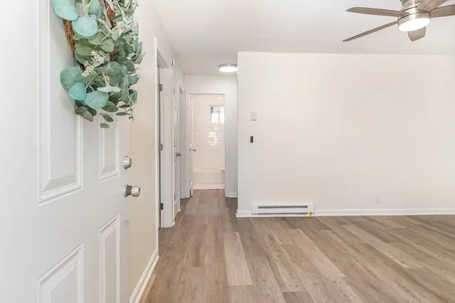 a view of a hallway with wooden floor and table