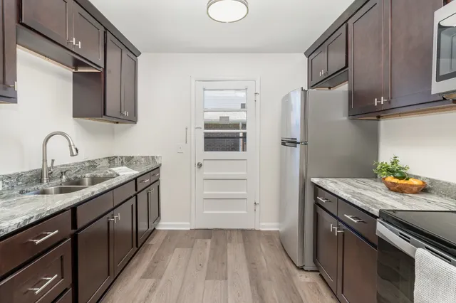 a kitchen with stainless steel appliances granite countertop a sink stove and refrigerator