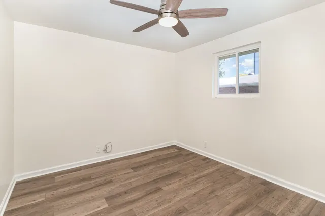 an empty room with a window and ceiling fan
