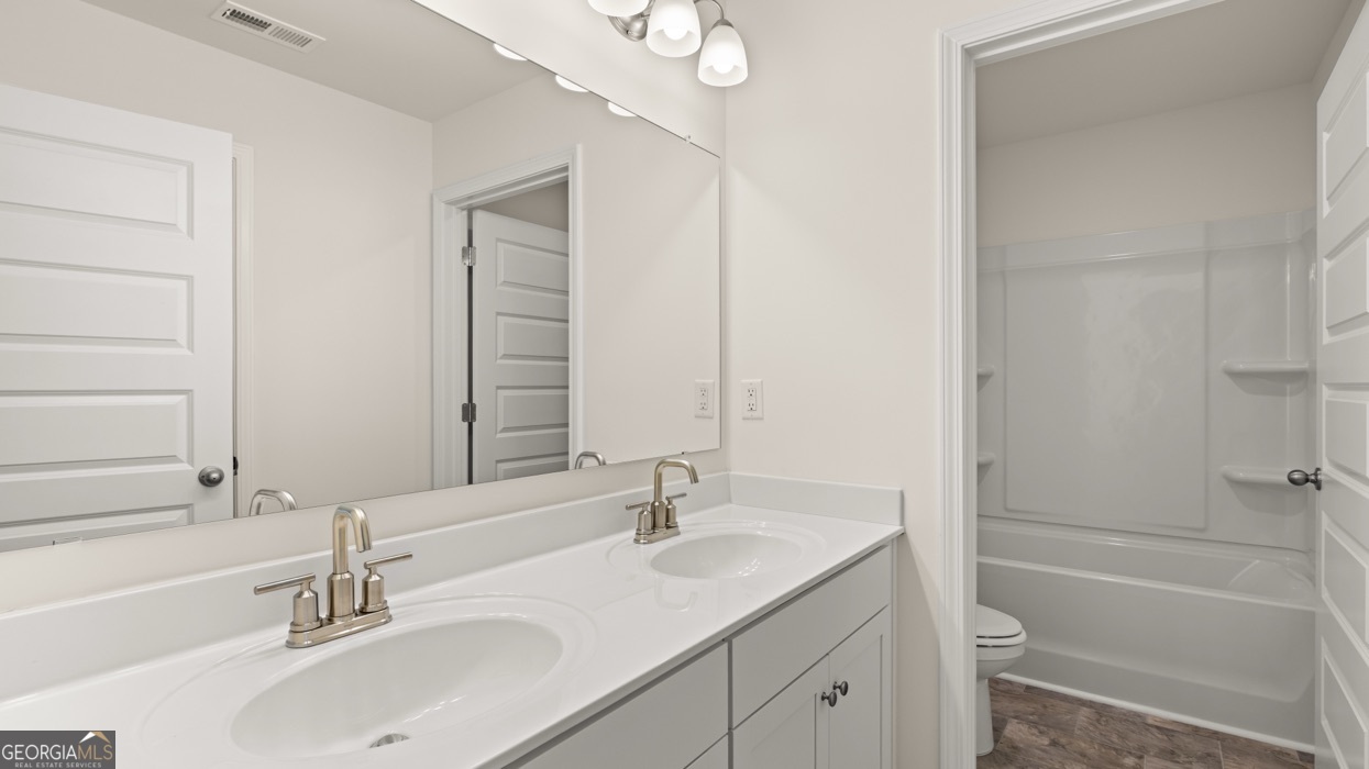 13604 Whitman Lane Covington, GA 30014 - Photo 48 of 52 a bathroom with a granite countertop sink a toilet and shower