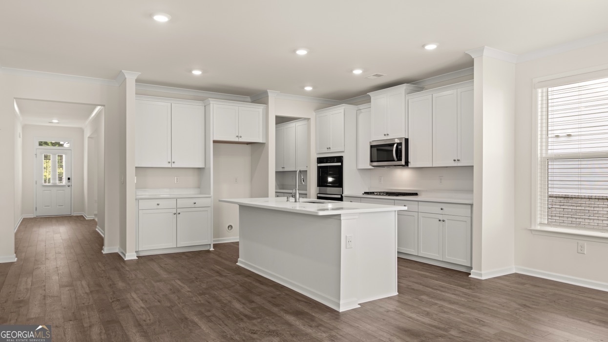 13604 Whitman Lane Covington, GA 30014 - Photo 9 of 52 a kitchen with stainless steel appliances granite countertop a refrigerator a sink dishwasher a stove and white cabinets with wooden floor