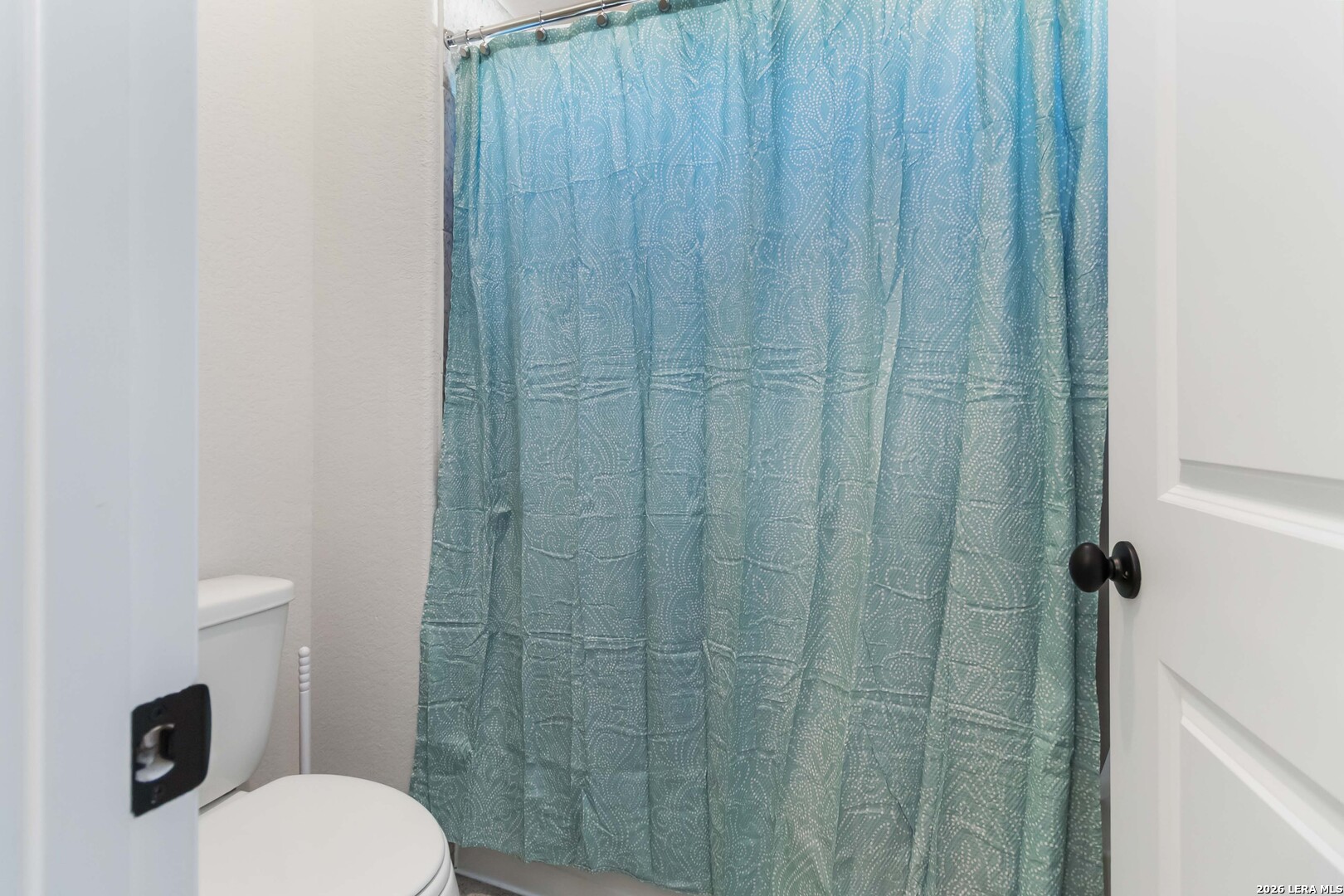 8024 Trail Grant Schertz, TX 78154 - Photo 12 of 20 a bathroom with a toilet and a shower curtain