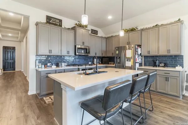 a kitchen with kitchen island a sink stove and refrigerator