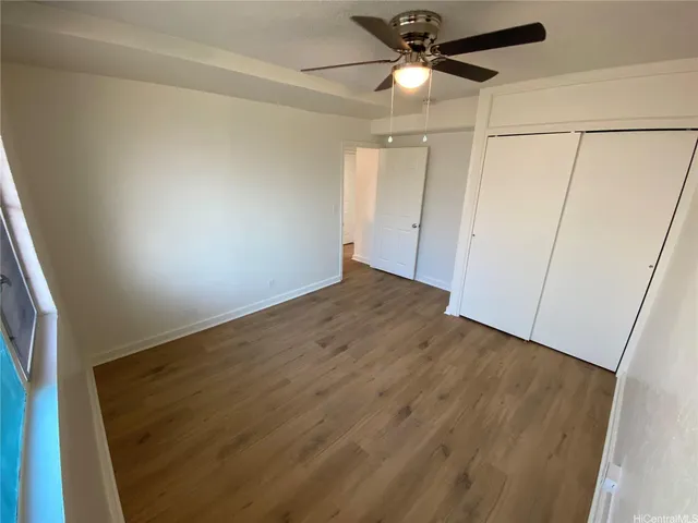 an empty room with a ceiling fan and hardwood floor