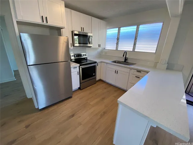 a kitchen with stainless steel appliances a refrigerator sink and microwave