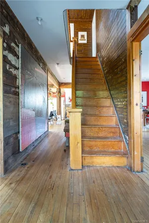 a view of a hallway with wooden floor and staircase