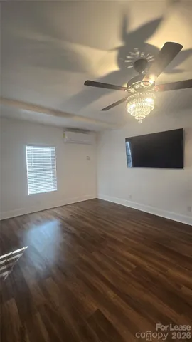 a view of a livingroom with wooden floor and a ceiling fan