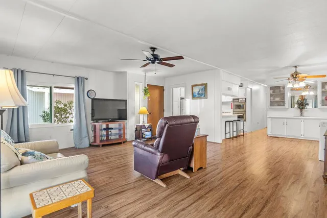a living room with furniture a flat screen tv and a large window