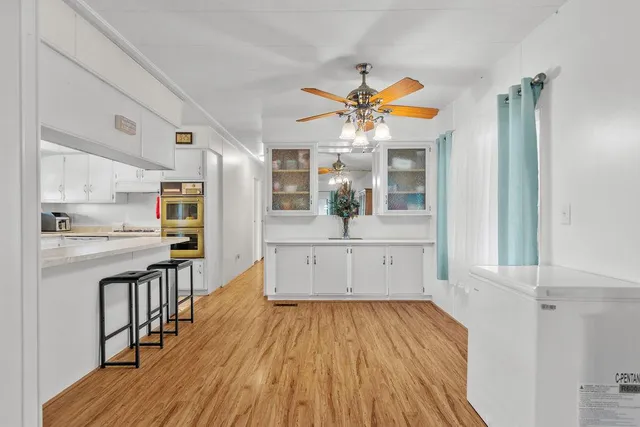 a view of a living room and kitchen with wooden floor
