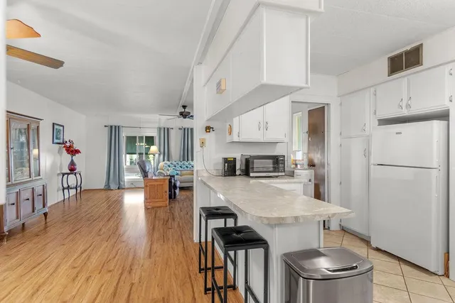 a kitchen with a table chairs refrigerator and cabinets