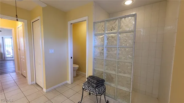 a bedroom with a bed and a lamp on dresser