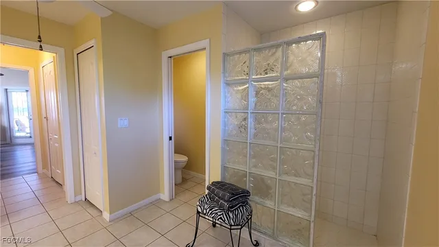 a bedroom with a bed and a lamp on dresser