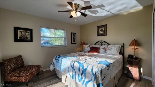 a bedroom with bed and two window