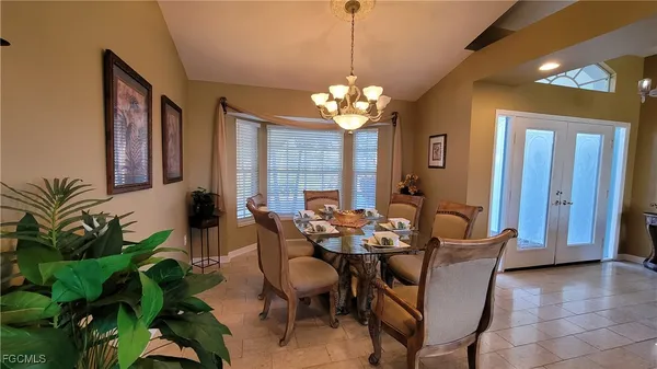 a dining room with furniture potted plants and wooden floor