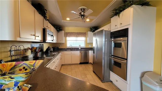 a kitchen with stainless steel appliances granite countertop a refrigerator a stove and a sink with wooden floor
