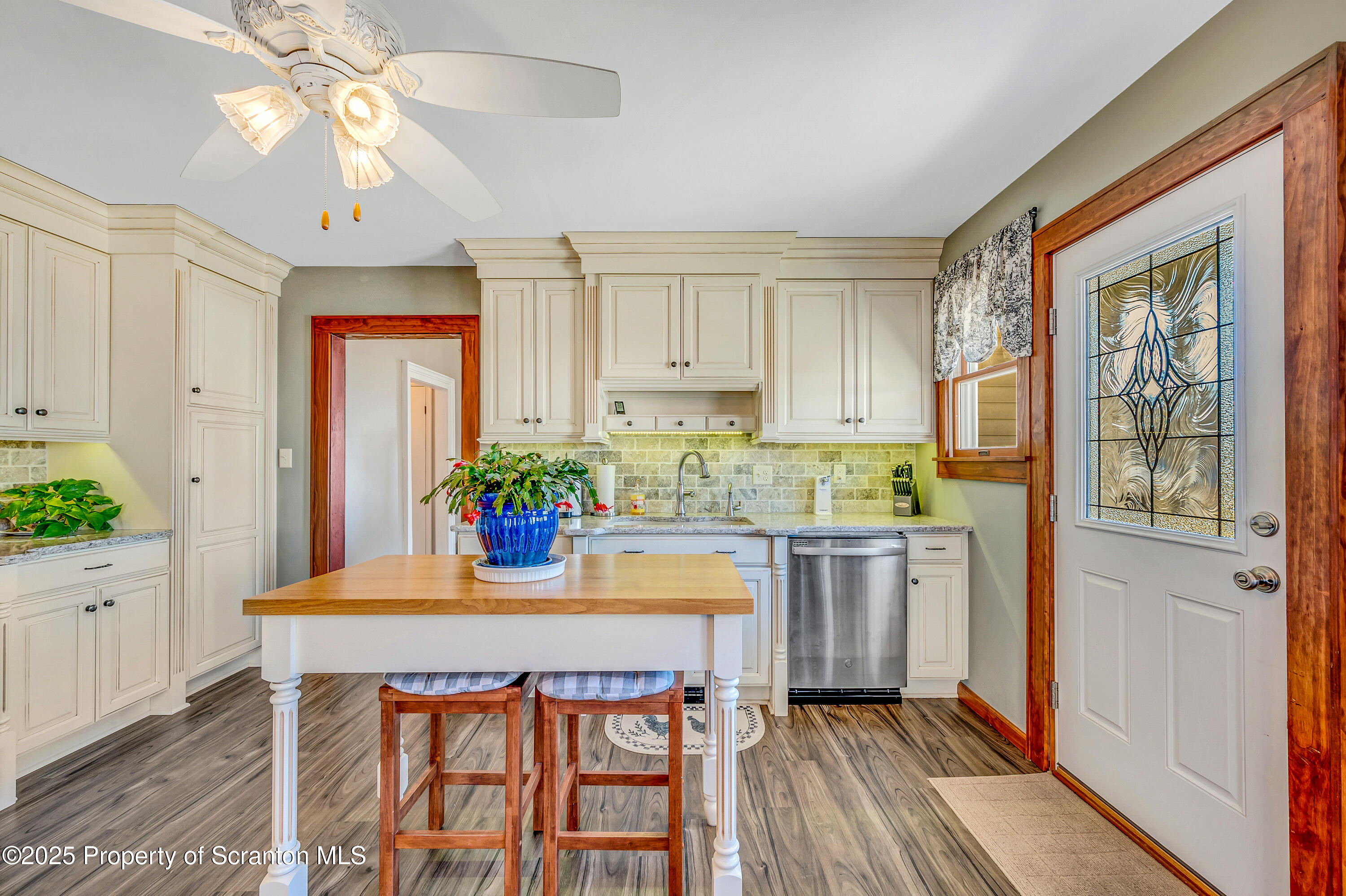 5115 State Rte 3013 Springville, PA 18844 - Photo 38 of 74 a kitchen with stainless steel appliances granite countertop a stove a refrigerator a sink dishwasher and white cabinets with wooden floor