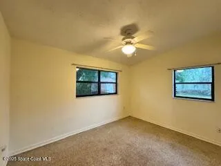 a view of a big room with a ceiling fan and window