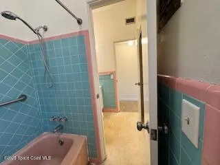 a bathroom with a tub a sink and shower