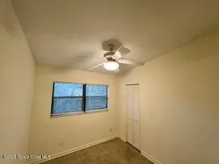 a view of a livingroom with a ceiling fan and window