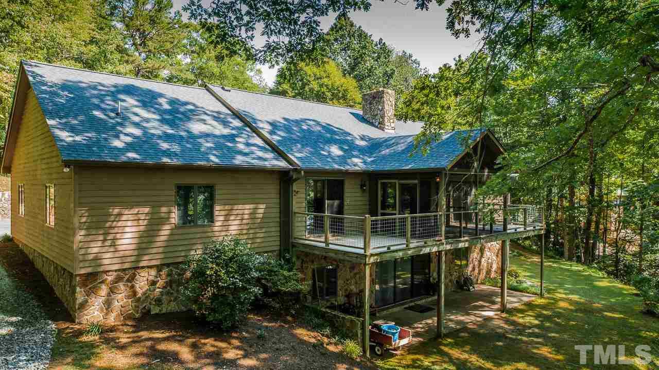 49 Stonegate Drive Roxboro, NC 27574 - Photo 22 of 30 a backyard of a house with table and chairs under an umbrella