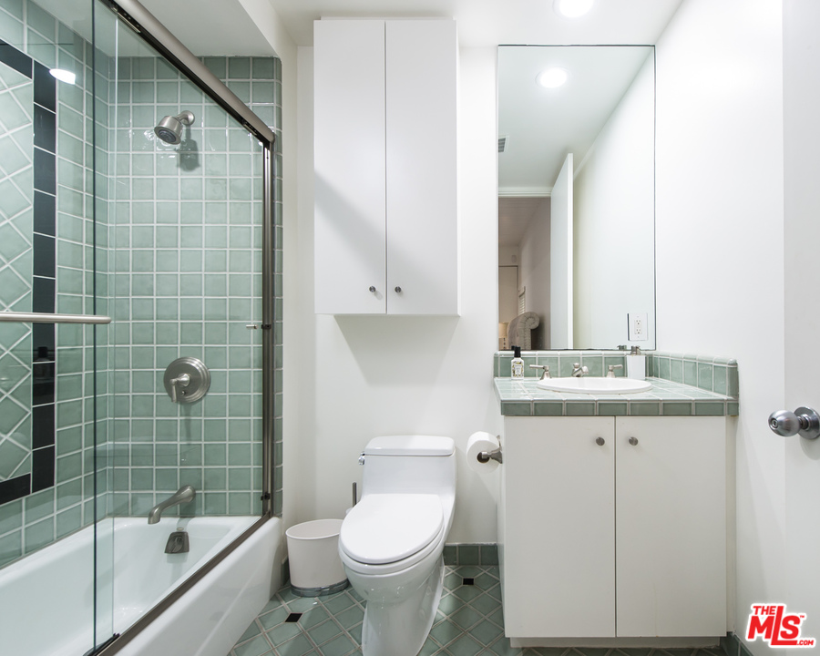 1908 North Beverly Drive Beverly Hills, CA 90210 - Photo 27 of 32 a bathroom with a granite countertop toilet a sink and a bathtub