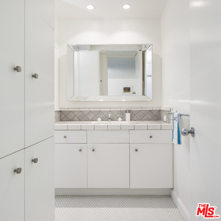1908 North Beverly Drive Beverly Hills, CA 90210 - Photo 30 of 32 a bathroom with a sink and a mirror