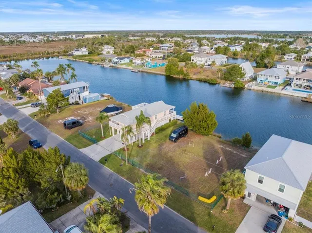 an aerial view of residential houses with outdoor space and lake view