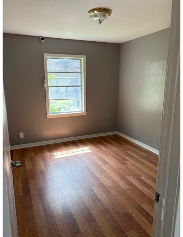 1213 8th Street Rosenberg, TX 77471 - Photo 4 of 7 an empty room with wooden floor and windows
