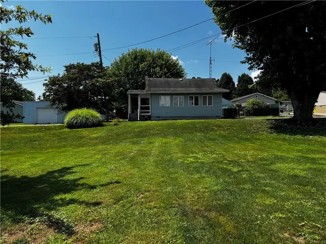 a view of house with yard and outdoor seating