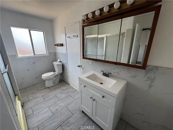 a bathroom with a sink a toilet and mirror