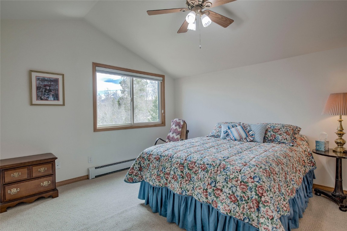 43 Lacy Drive Silverthorne, CO 80498 - Photo 22 of 35 a bedroom with a bed and a chandelier