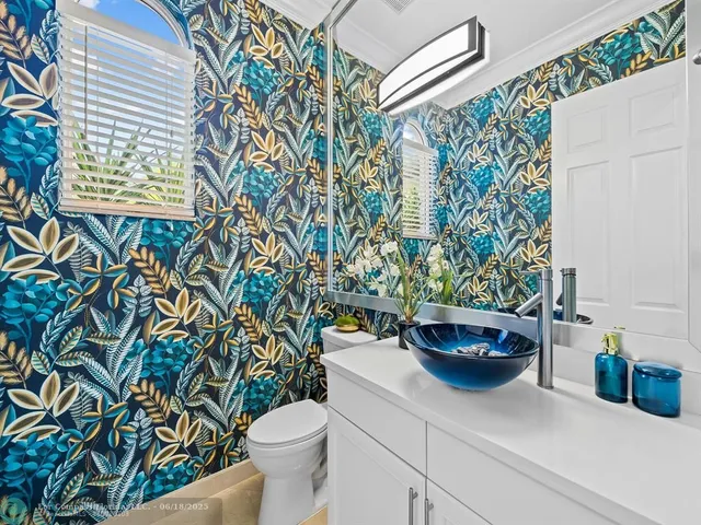 a living room with furniture a large window with kitchen view