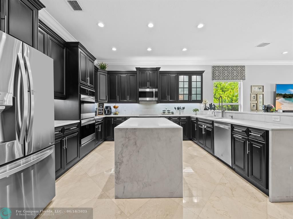 10741 Pine Lodge Trail Davie, FL 33328 - Photo 17 of 48 a large kitchen with stainless steel appliances kitchen island granite countertop a large counter top cabinets a sink and a refrigerator