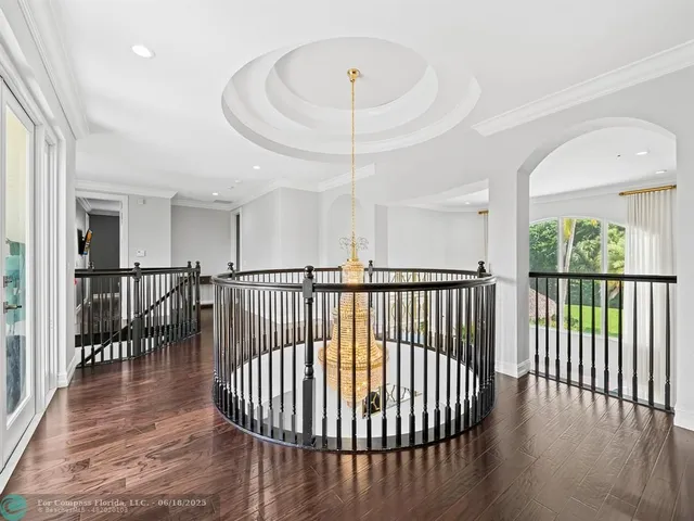 a room with wooden floor pool table and a chandelier
