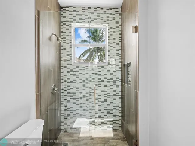 a view of a bedroom with wooden floor closet and windows