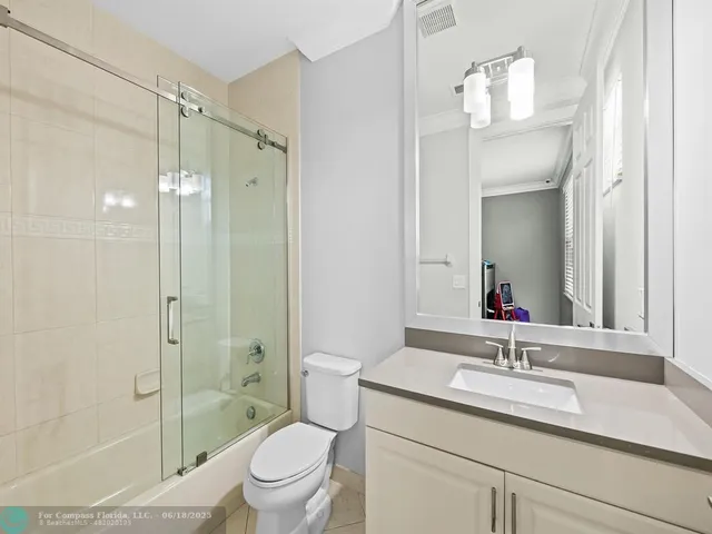 a bedroom with a bed painting on wall and a large window