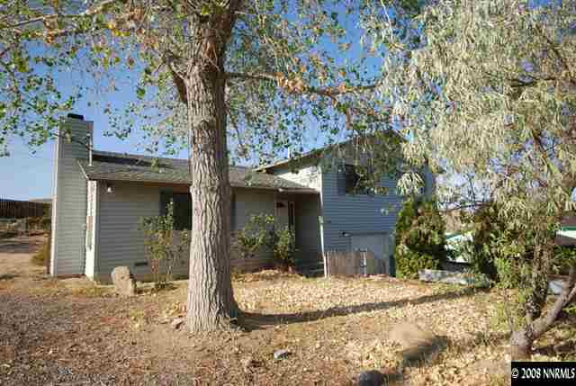 a front view of a house with a tree