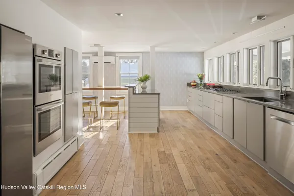 a kitchen with stainless steel appliances a refrigerator and wooden floor