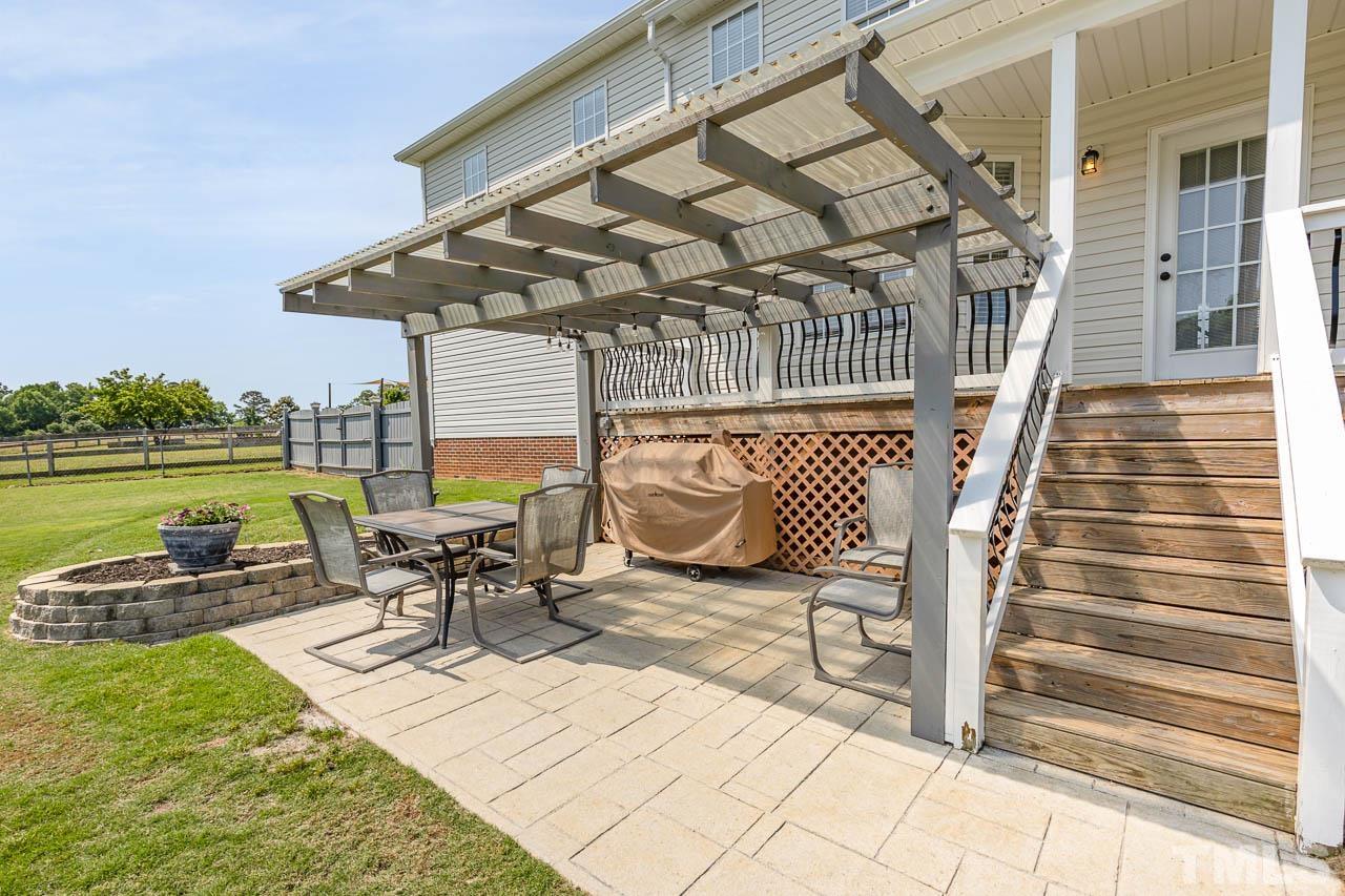407 Ina Joe Place Willow Spring, NC 27592 - Photo 19 of 26 a view of a patio with a table chairs and wooden fence