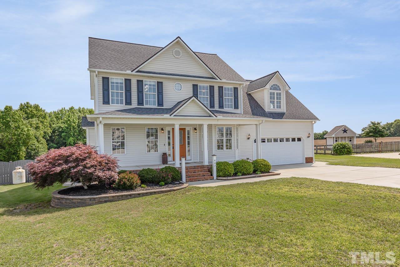407 Ina Joe Place Willow Spring, NC 27592 - Photo 2 of 26 a front view of a house with garden