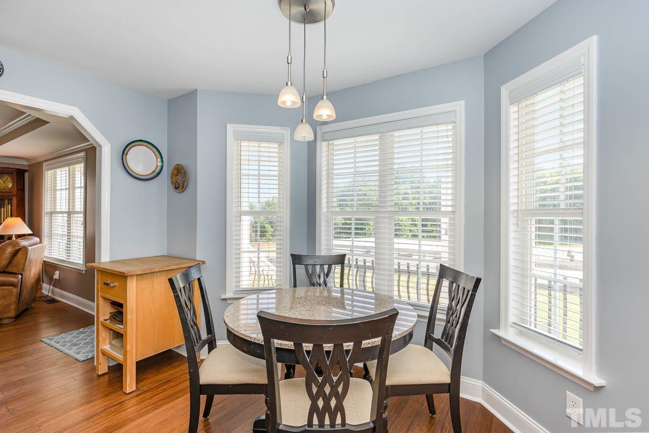 407 Ina Joe Place Willow Spring, NC 27592 - Photo 8 of 26 a view of a dining room with furniture window and wooden floor