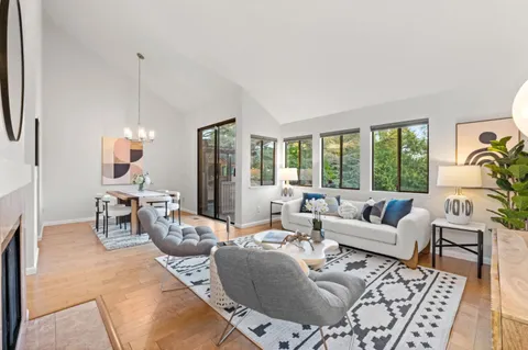 a dining room with wooden floor a glass table and chairs
