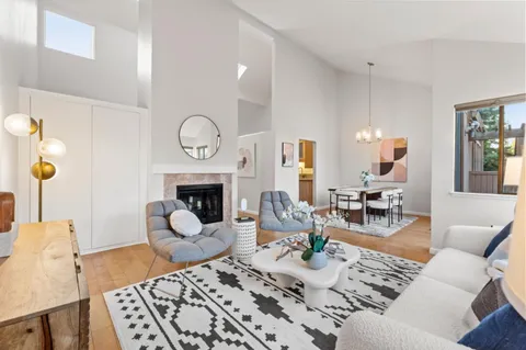 a living room with furniture large window and a fireplace