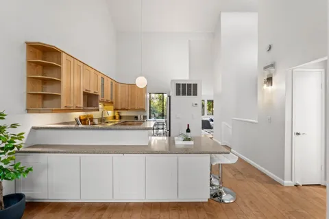 a kitchen with stainless steel appliances granite countertop a sink dishwasher stove and cabinets with wooden floor