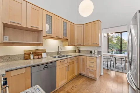 a kitchen with stainless steel appliances granite countertop a stove sink and cabinets