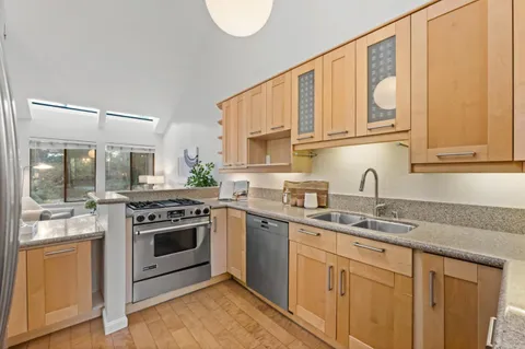 a kitchen with stainless steel appliances granite countertop a refrigerator sink and stove