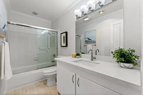 a bathroom with a granite countertop double vanity sink and mirror