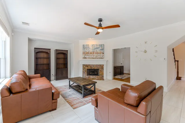 a living room with furniture ceiling fan and a fireplace