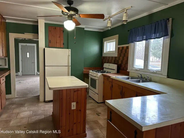 a kitchen with kitchen island granite countertop a sink a counter top space and stainless steel appliances