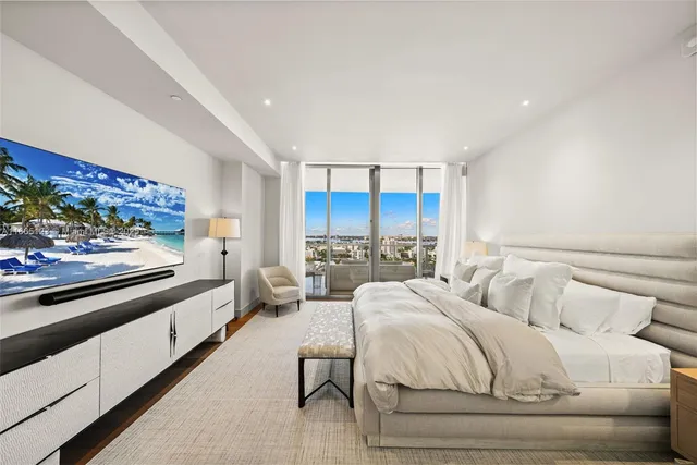 a large bedroom with a bed and glass wall